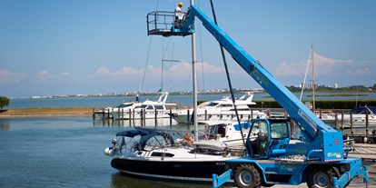 Yachthafen - Trockenliegeplätze - Italien - Hubstapler, Hubkorb und Kran für Arbeiten am Mast. - Marina Punta Gabbiani