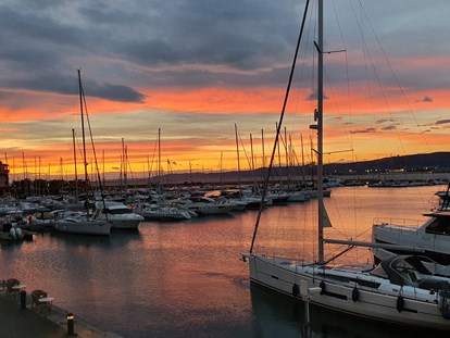 Yachthafen - Badestrand - Sonnenuntergang - Porto San Rocco Marina Resort S.r.l.
