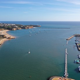 Marina: Hafeneinfahrt im Hintergrund und Ankerbucht am Rio Arade mit der Einfahrt zur Marina de Portimao auf der rechten Seite - Marina de Portimao